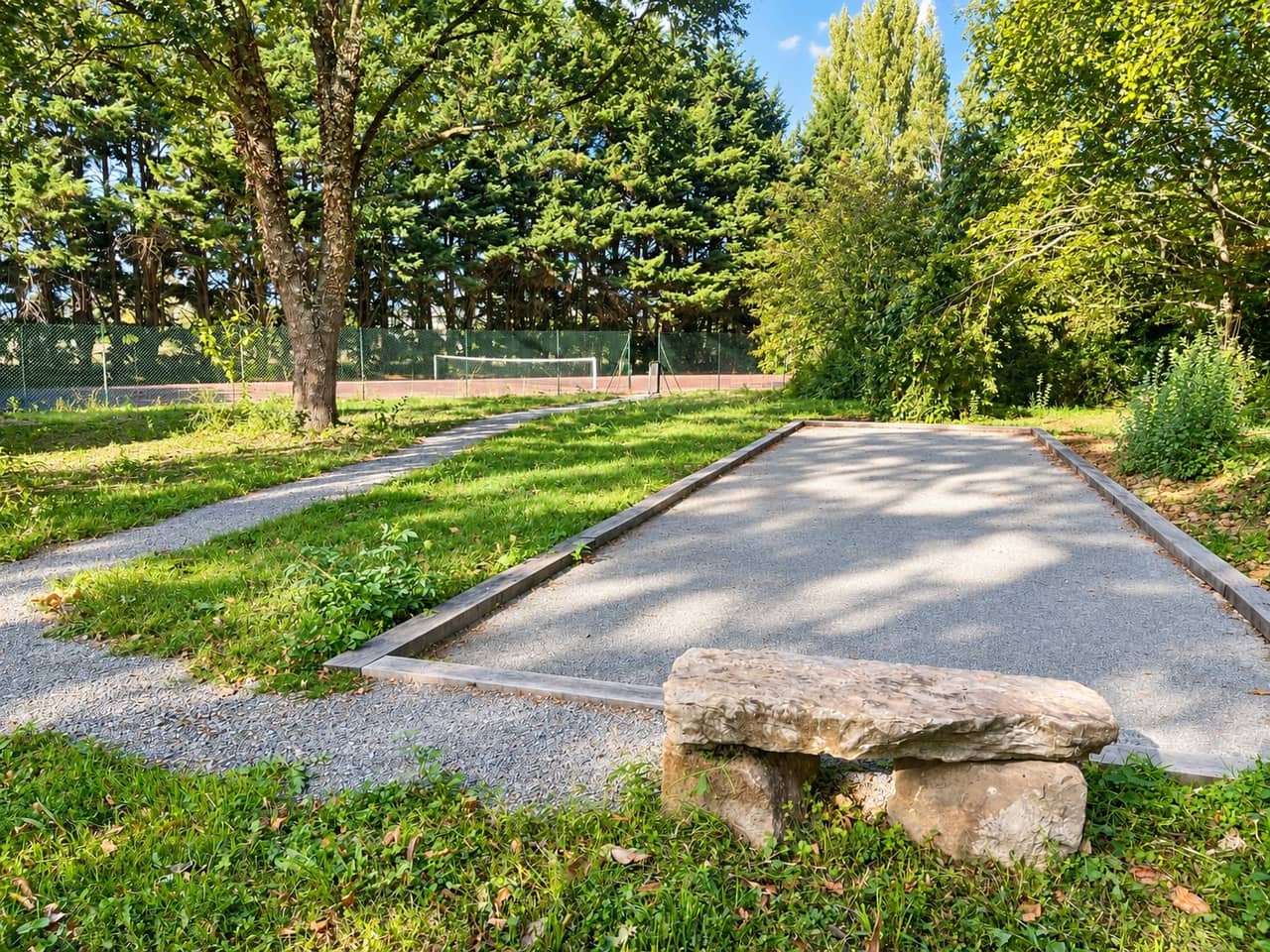 Le terrain de pétanque du domaine, le court de tennis visible en arrière-plan